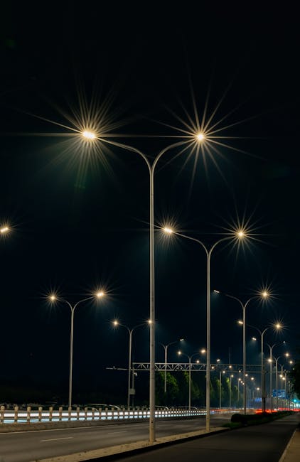A row of illuminated street lamps casting light on a Beijing road at night.